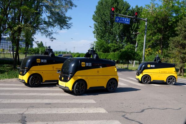 Беспилотные автомобили доставки проводят дорожные испытания 7 мая 2024 года в Пекине, Китай.