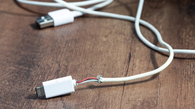 Неисправное зарядное устройство с оголенными проводами