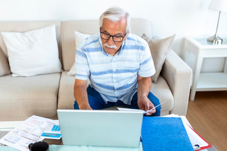 focused-greyhaired-elderly-man-sit-couch-reading-bank-notifications-calculating-domestic-expenditures-concentrated-modern-mature-male-consider-financial-paperwork-pay-bills-laptop-online_657921-1007