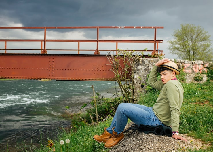 man-wearing-hat-sitting-near-flower-river_23-2148187269