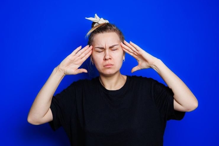 portrait-young-woman-blue-background-holding-her-head-headache-migraine-woman_173815-39589