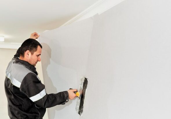 worker-attaching-wallpaper-man-is-putting-up-wallpapers-wall-home-renovation-concept_166373-2213