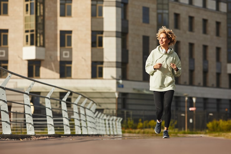 young-healthy-woman-sports-clothing-jogging-along-street-city_249974-6302