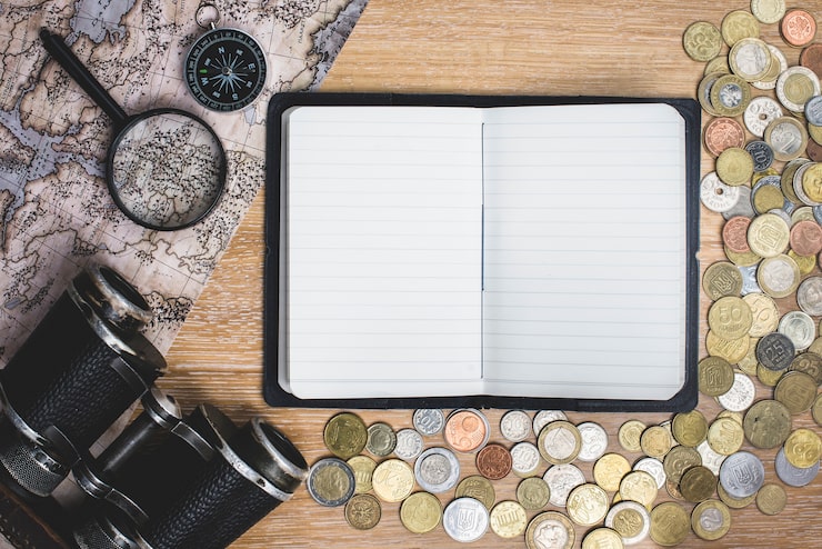 blank-notebook-with-coins-travel-objects_23-2147604765