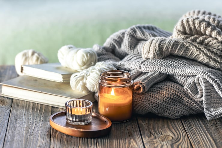 home-composition-with-burning-candles-knitted-elements-books_169016-51182