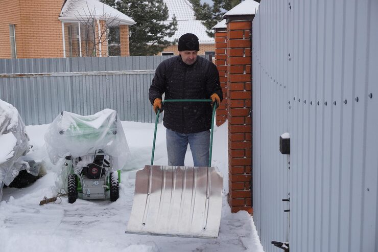 man-cleans-snow-winter-courtyard-house_221439-1895