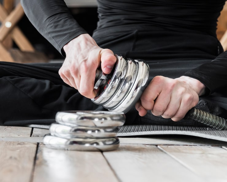 man-setting-up-discs-dumbbell_23-2148241639