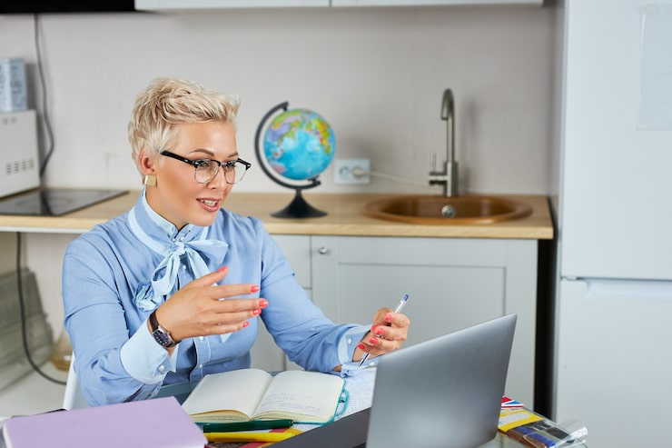 portrait-confident-good-looking-teacher-sitting-table_183219-1782