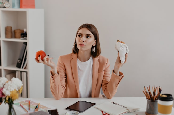 portrait-lady-with-short-hair-office-business-woman-thought-chooses-eat-burger-healthy-apple_197531-10714
